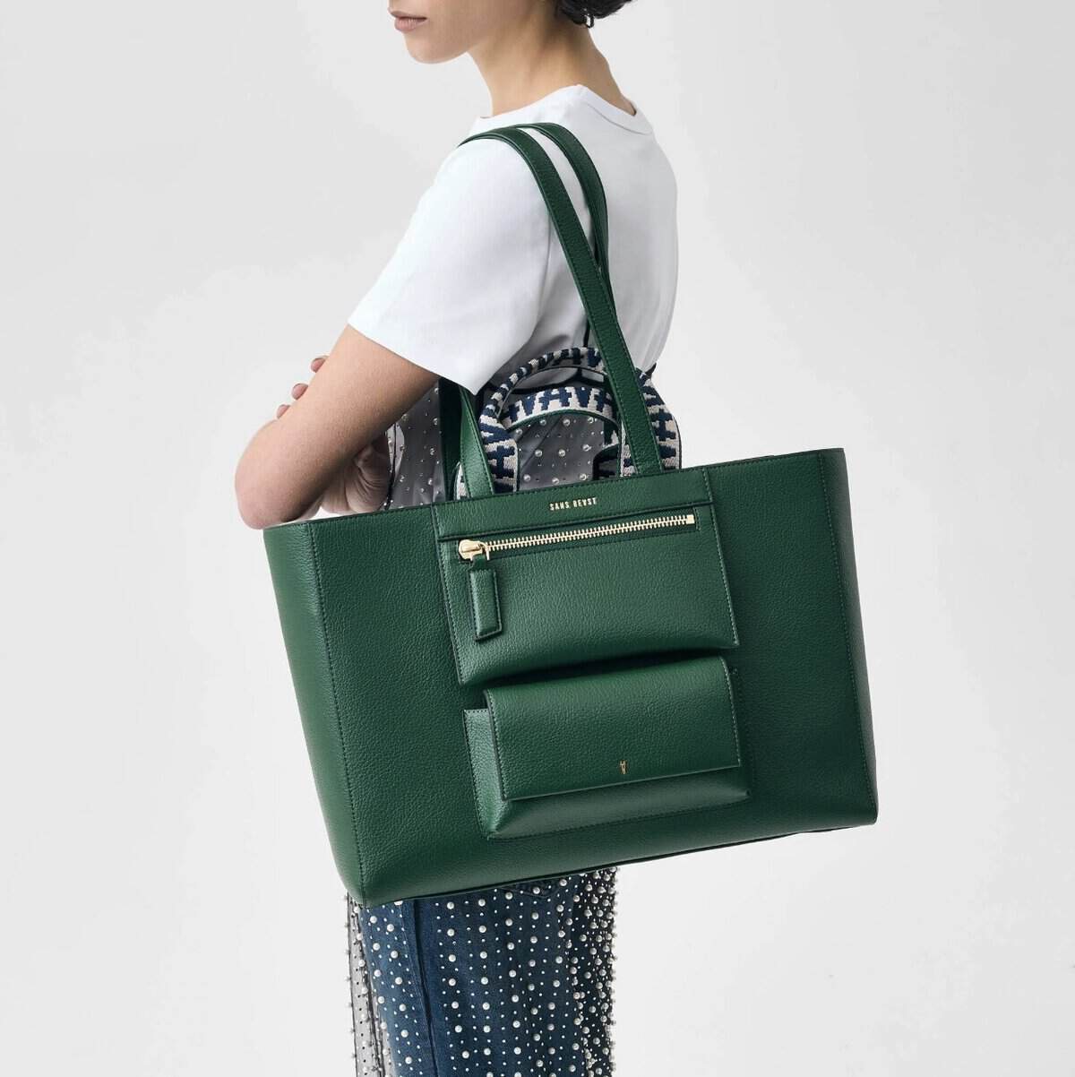 Elegant green vegan leather handbag with multiple pockets.