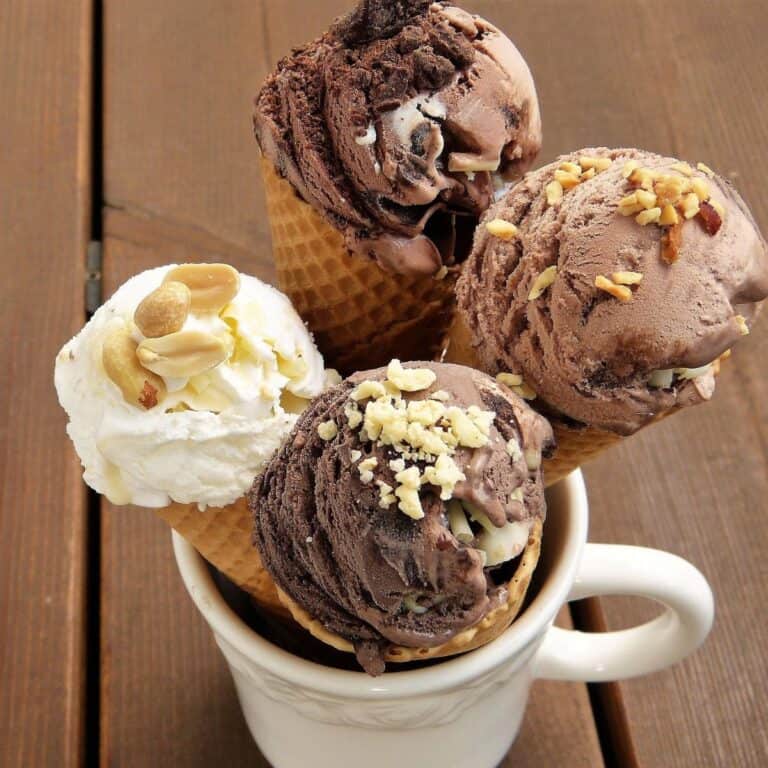 Assorted vegan ice cream cones with various flavors and toppings in a cup.