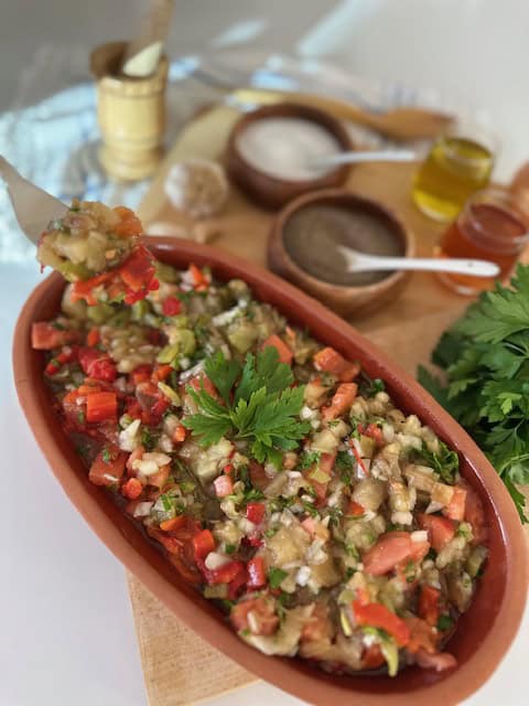 Colorful vegan eggplant dip with fresh herbs and vegetables.