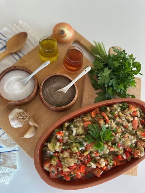Colorful vegan vegetable dip with herbs, spices, and oils on a wooden board.
